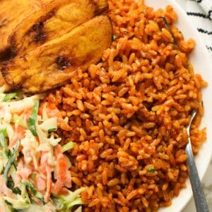 Diving into freshly made Nigerian jollof rice with fried plantains and slaw