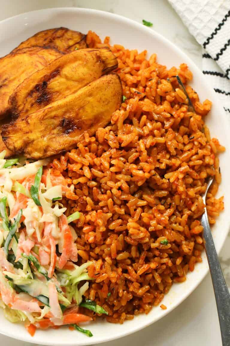 Diving into freshly made Nigerian jollof rice with fried plantains and slaw