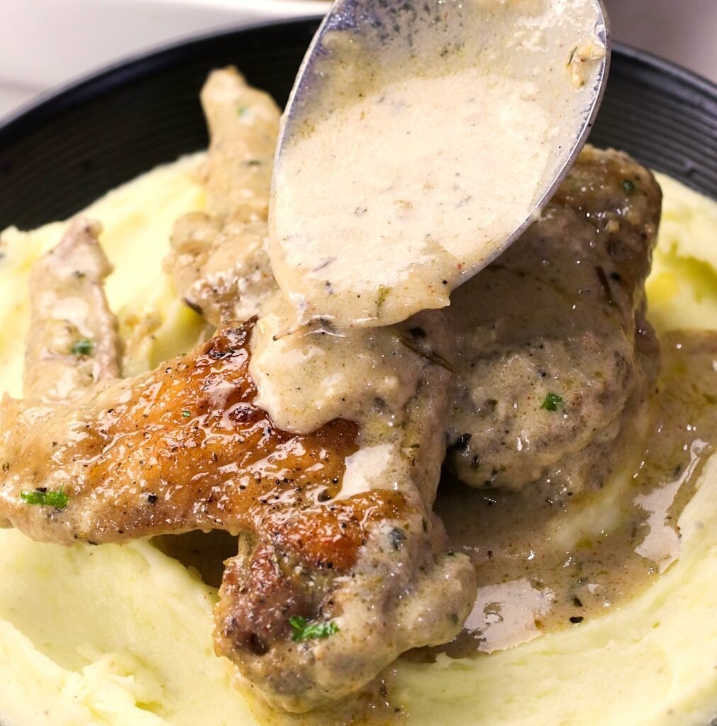 Smothering fall-off-the-bone chicken wings with creamy gravy
