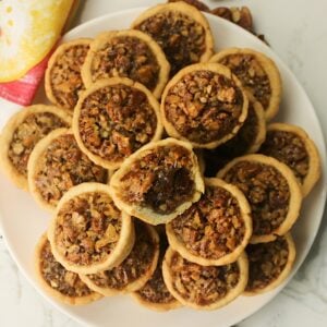 A plate full of decadent Southern pecan tassies ready to serve