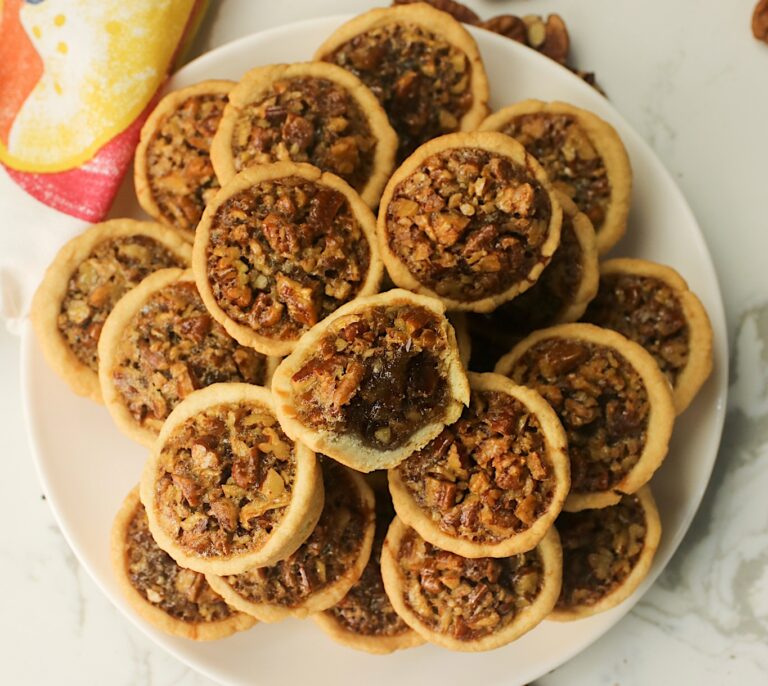 A plate full of decadent Southern pecan tassies ready to serve