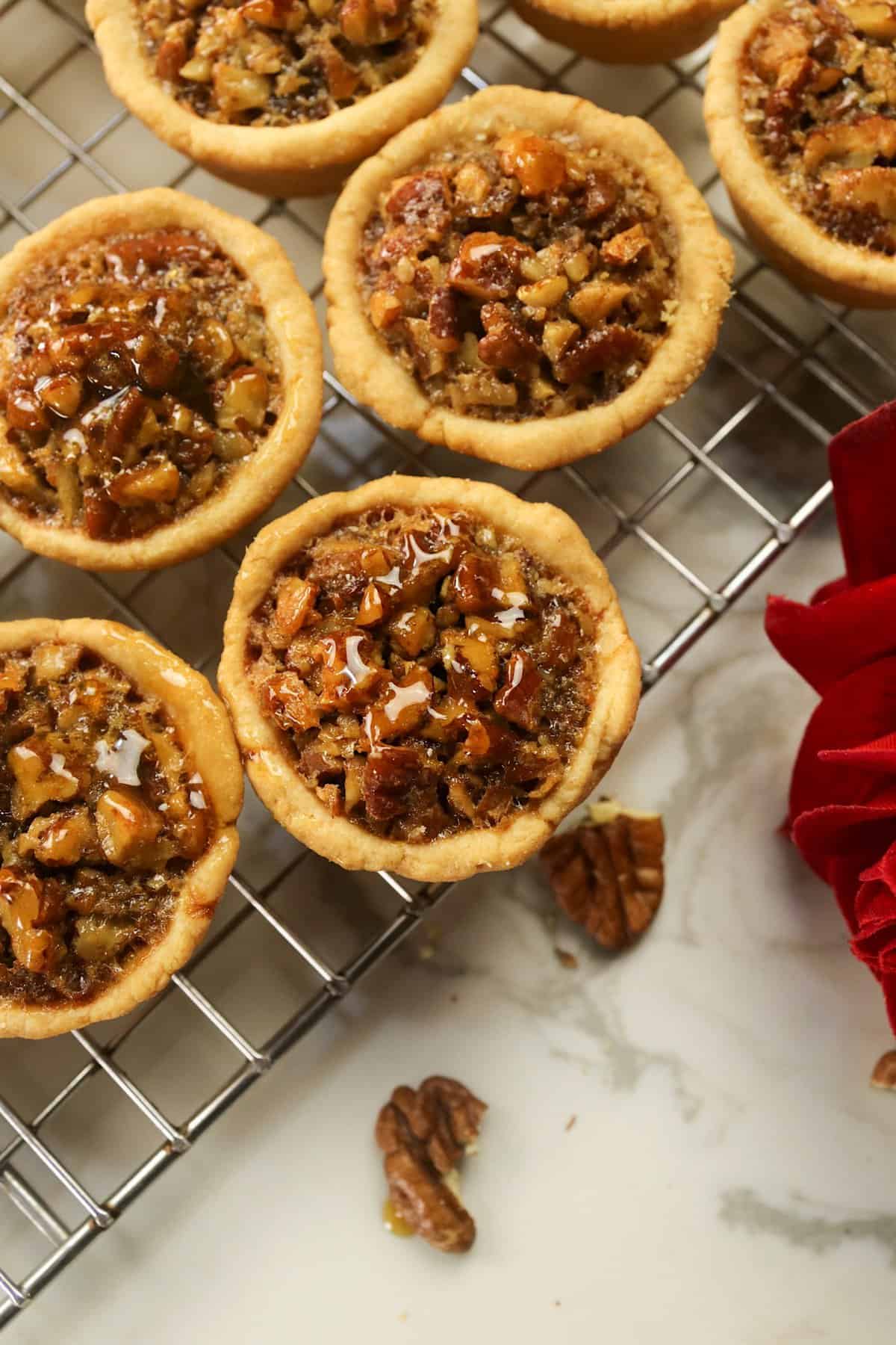 Pecan tassies fresh from the oven and cooling on a wire rack