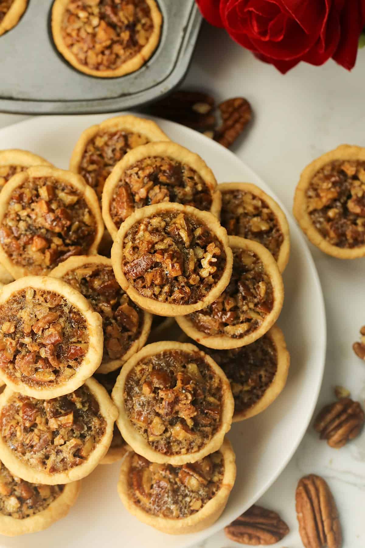 Loading a plate with mini pecan tassies to satisfy a sweet tooth craving