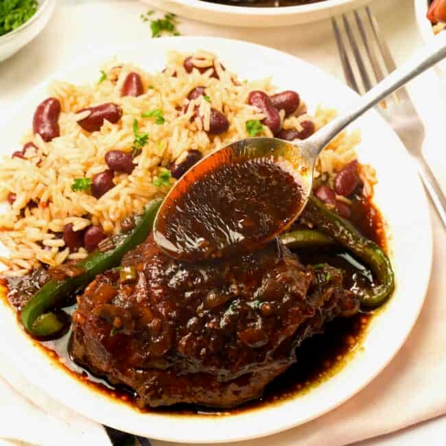 Serving brown stew chicken with rice and peas for an amazing comfort food dinner