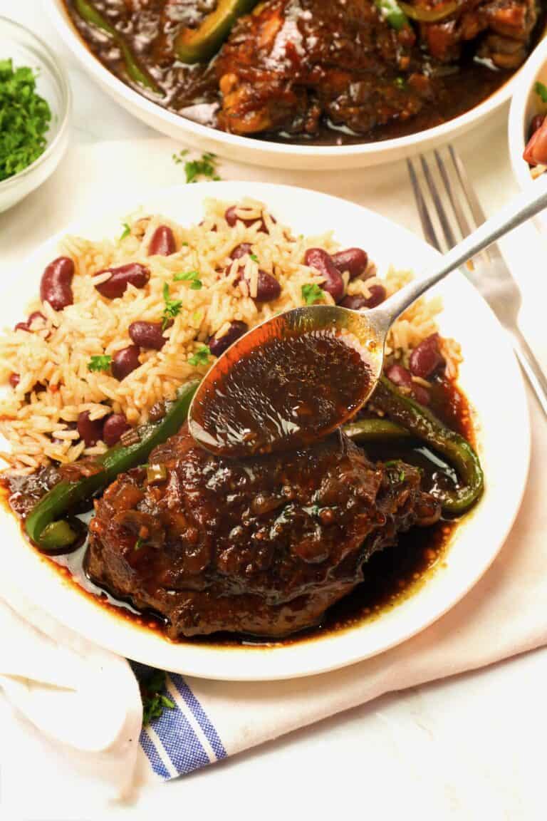 Serving brown stew chicken with rice and peas for an amazing comfort food dinner