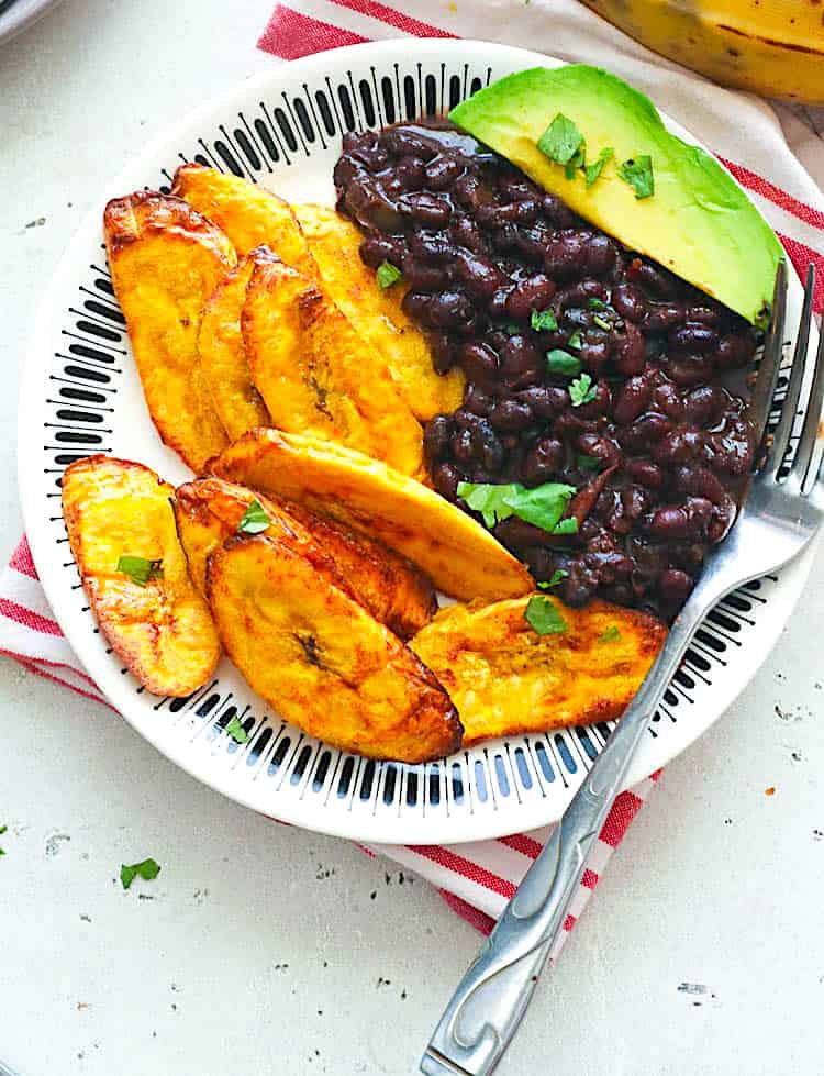 Enjoying air fryer plantains with black beans and avocados.