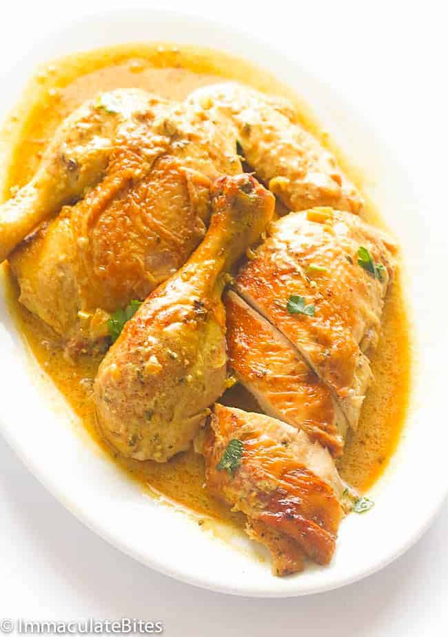 Serving up chicken with the coconut milk braising sauce on a white platter.