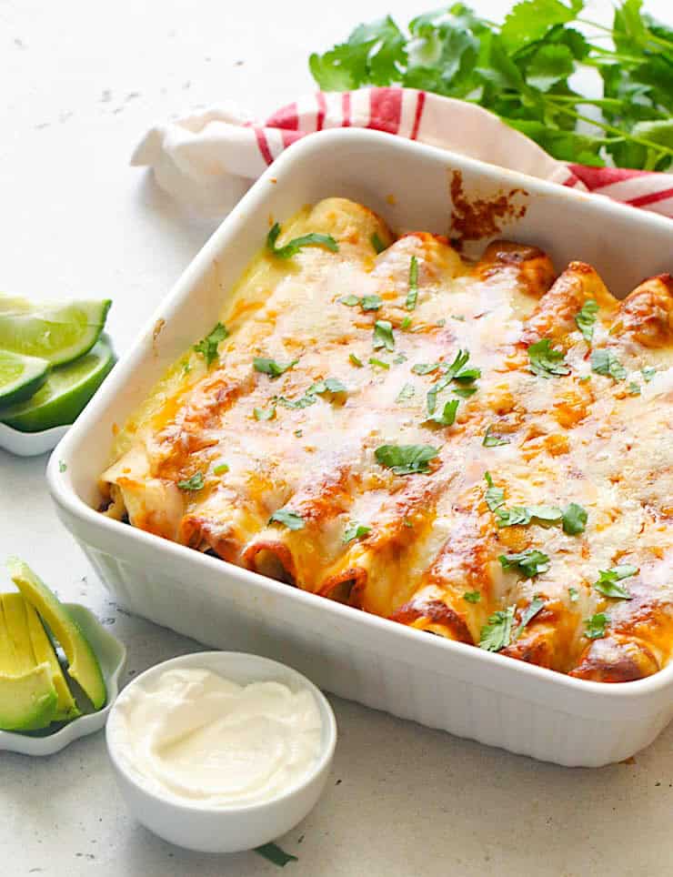 Enchiladas fresh from the oven and ready to enjoy with sour cream and avocados. 