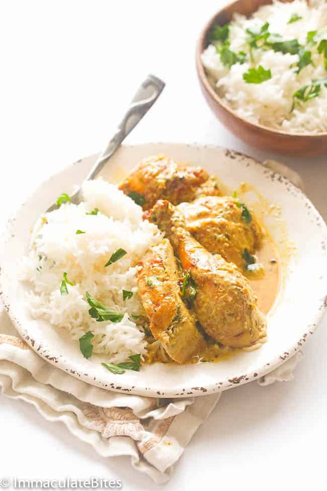Chicken braised in coconut milk served over rice and garnished with cilantro.