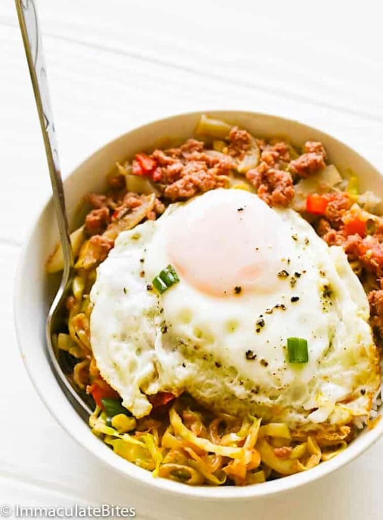 Caribbean corned beef and cabbage topped with a fried egg for comfort food from the Islands.