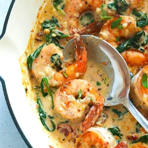 Creamy Tuscan shrimp in a decadent garlic sauce ready to serve over pasta.