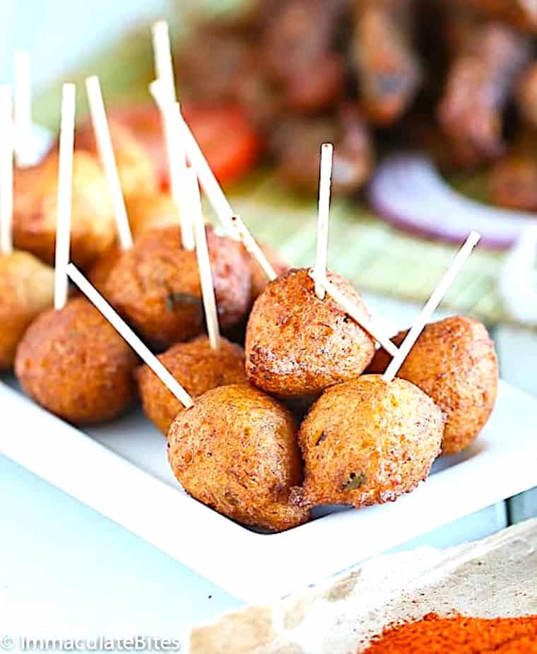 Putting toothpicks in plantain fritters for the perfect appetizer.
