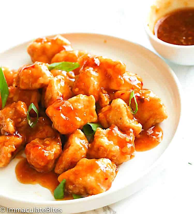 A steaming hot plate of chicken smothered in a finger-licking-good orange sauce.