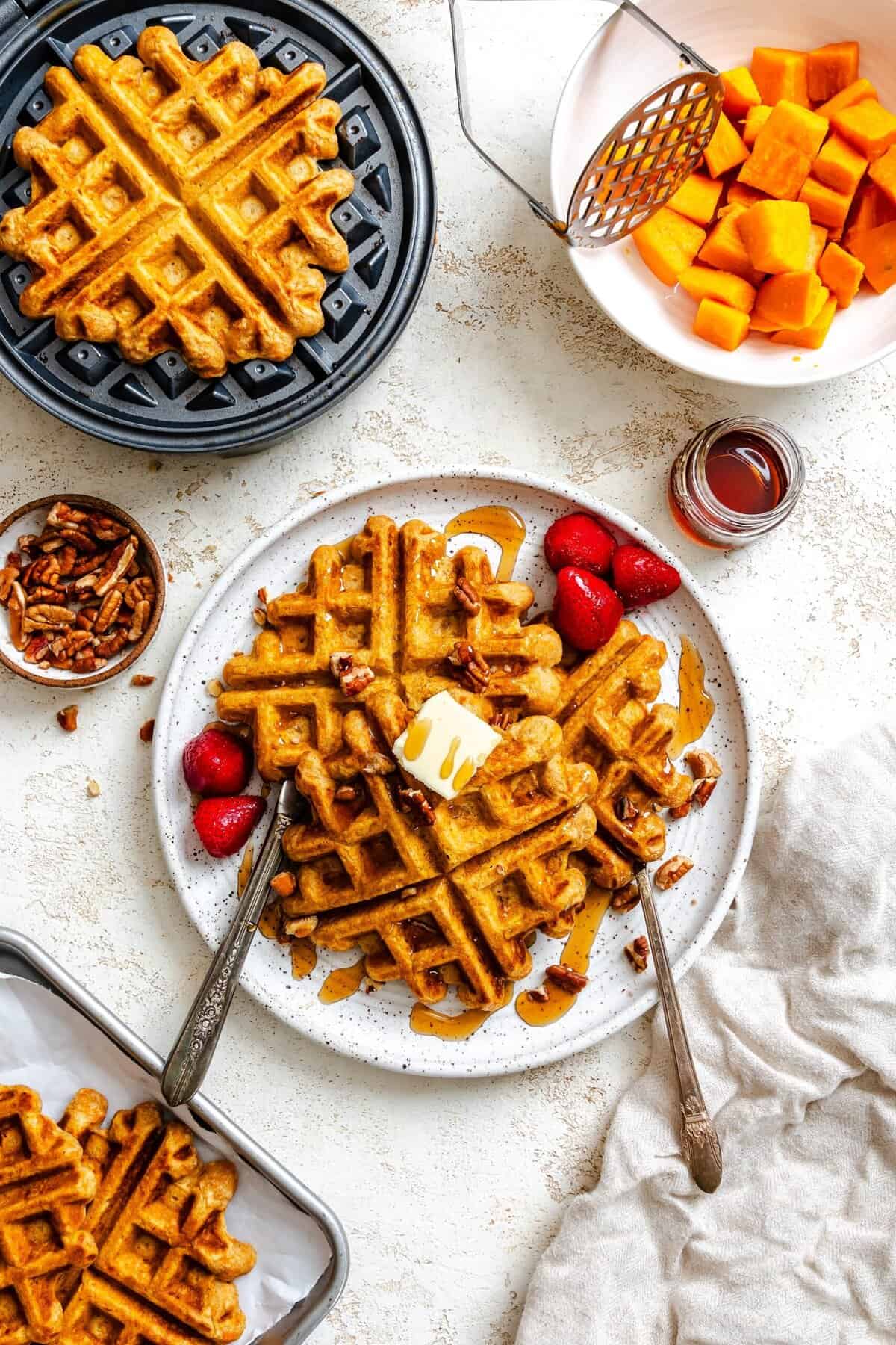 Sweet potato waffles with butter, syrup, pecans and strawberries is an amazing fall breakfast.