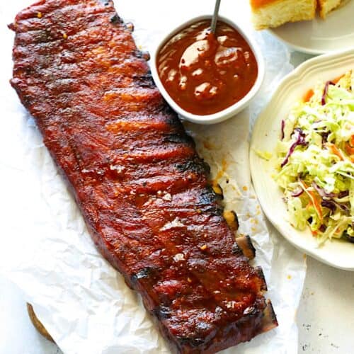 Slathering BBQ ribs with more sauce.