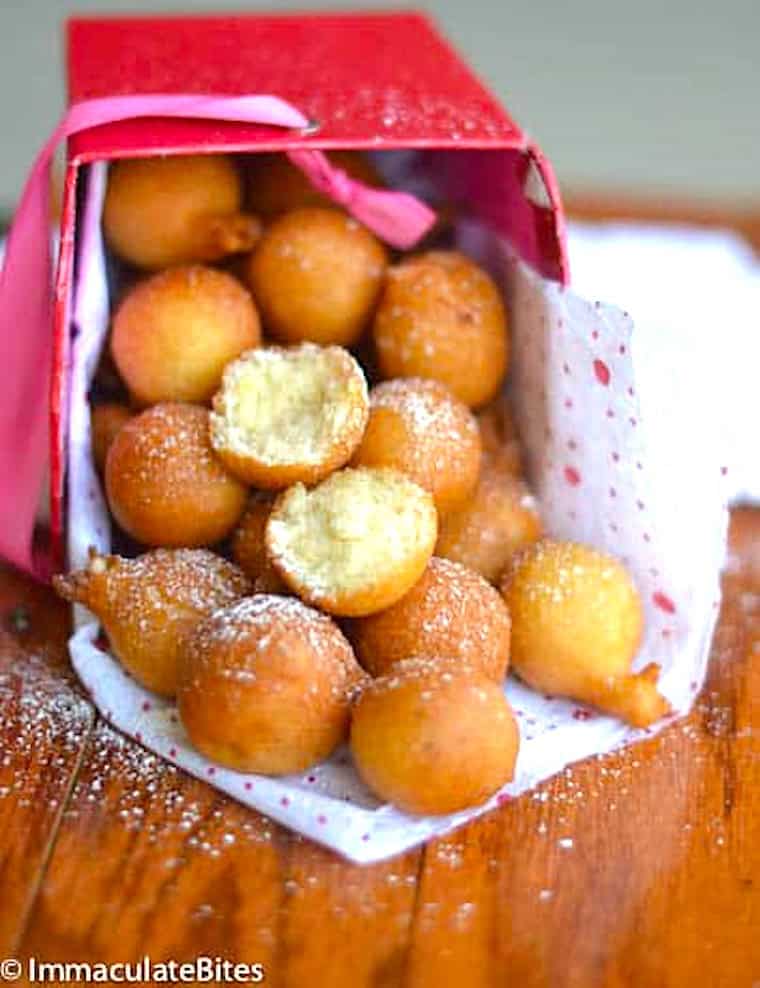 Breaking open a drop doughnut to reveal the pillowing interior.