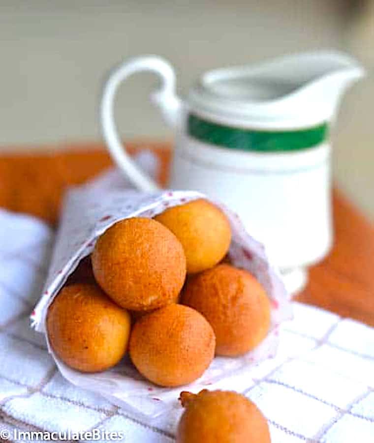 A cone filled with freshly fried donuts.