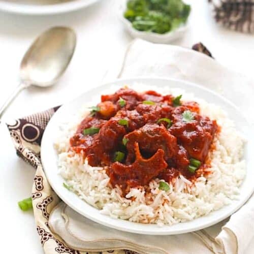 Enjoying freshly made spicy stew with oxtails over rice.