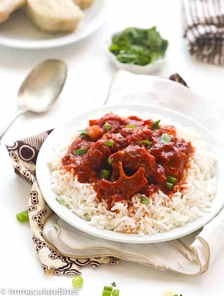 Enjoying freshly made spicy stew with oxtails over rice.