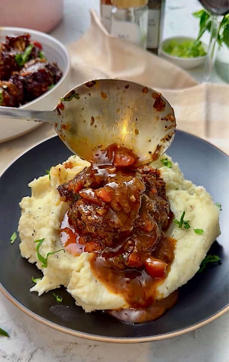 Serving braised oxtails with creamy mashed potatoes.