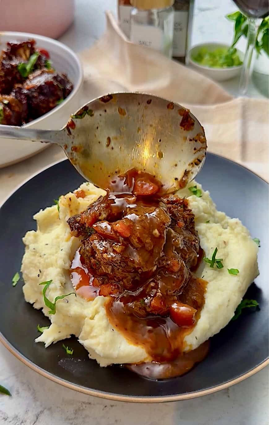Serving braised oxtails with creamy mashed potatoes.