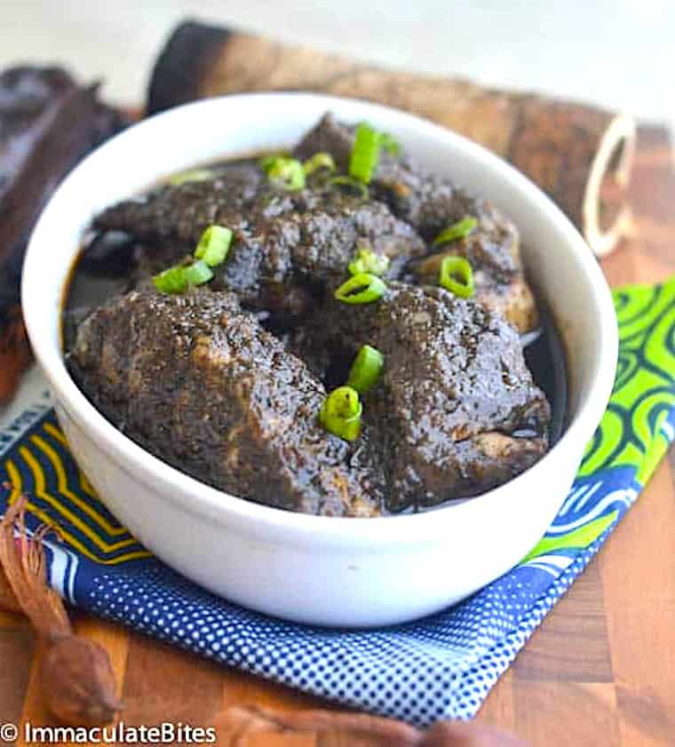 A bowl of African spicy black stew with catfish.