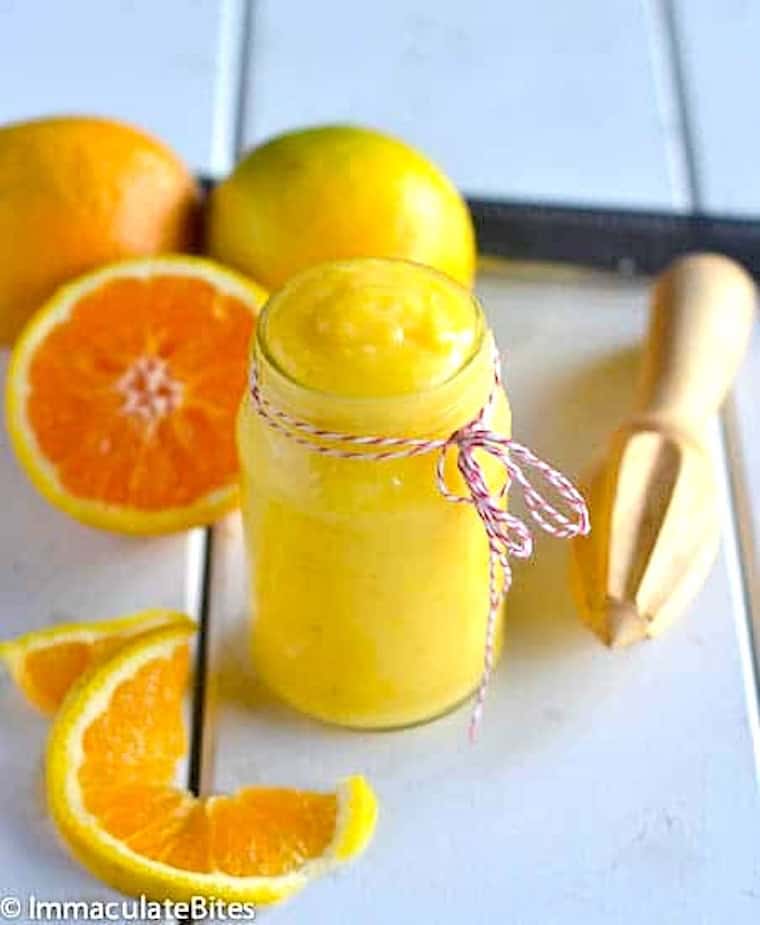 Freshly made orange curd cooling in a glass jar.