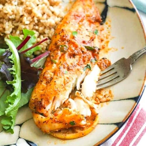 Forking into freshly baked fish with a baby greens salad and brown rice.