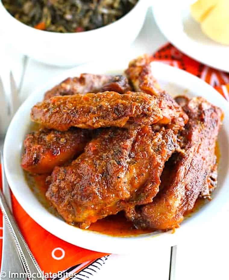 Serving up a platter full of African grilled chicken with stewed spinach.