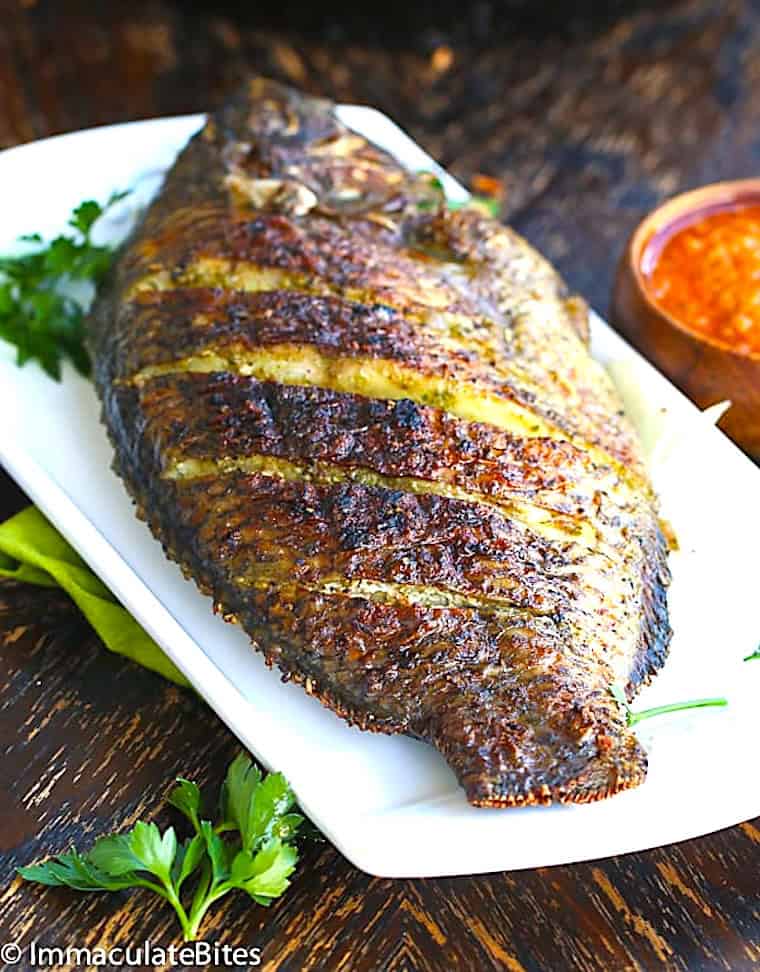 Enjoying grilled tilapia with red pepper sauce.