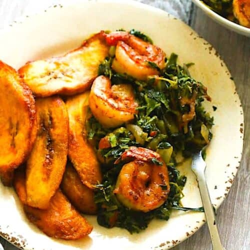 Enjoying a plate of stewed spinach with plantains.