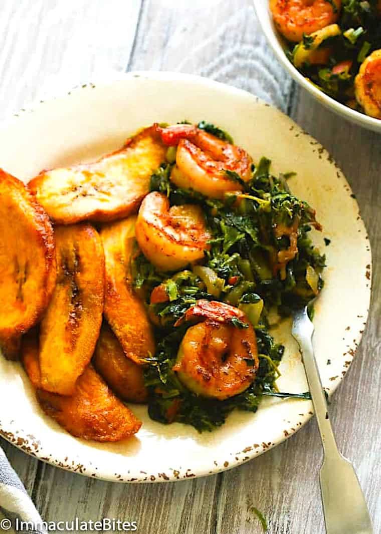 Enjoying a plate of stewed spinach with plantains.