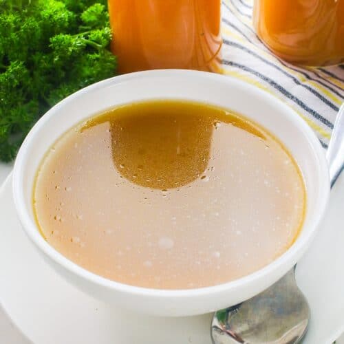 A steaming hot bowl of comforting chicken stock ready as is or for soup.
