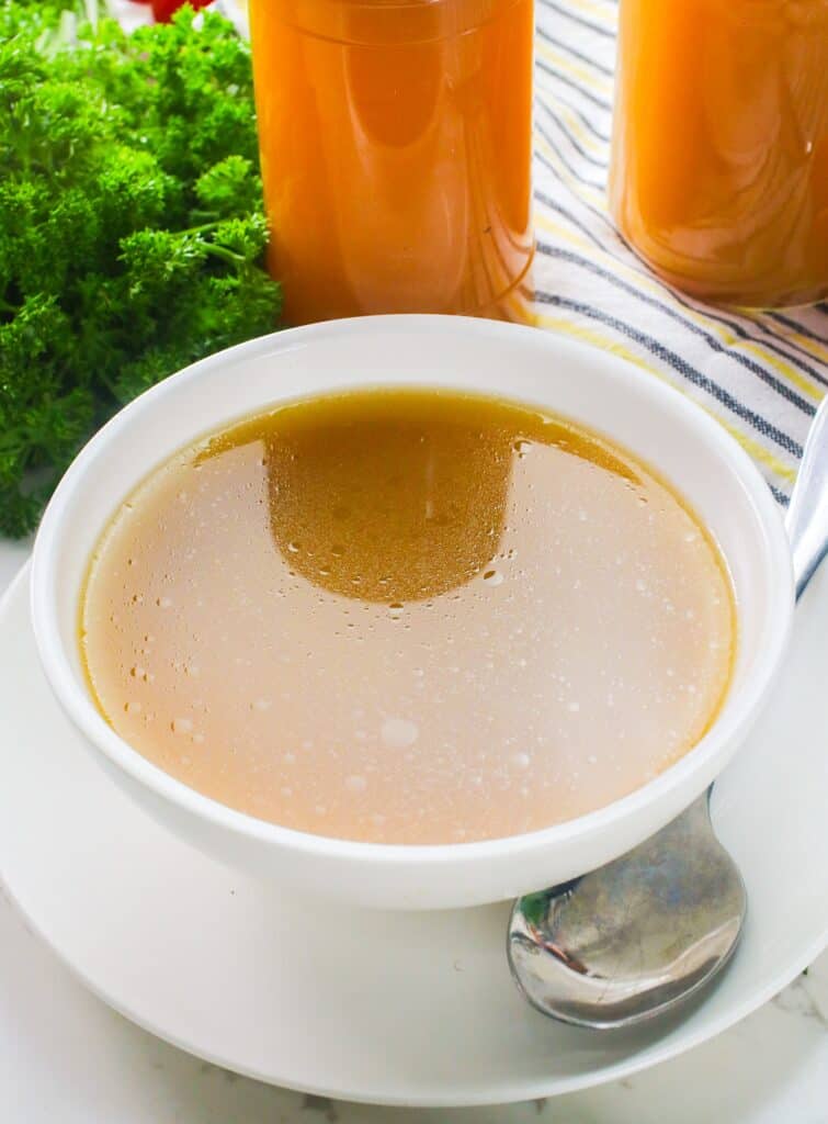 A steaming hot bowl of comforting chicken stock ready as is or for soup.