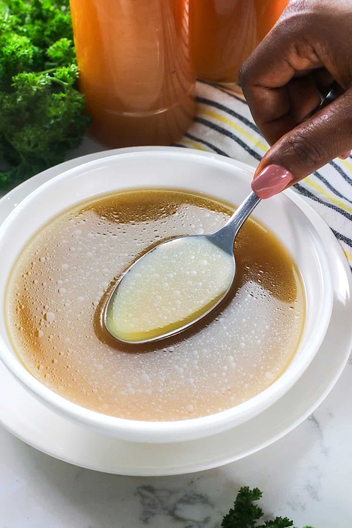 Spooning up homemade stock made from chicken.