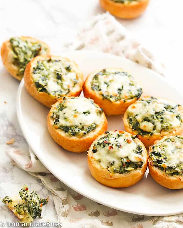 Enjoying a platter full of bread rolls stuffed with dip. Spinach and cheese make it extra delicious.