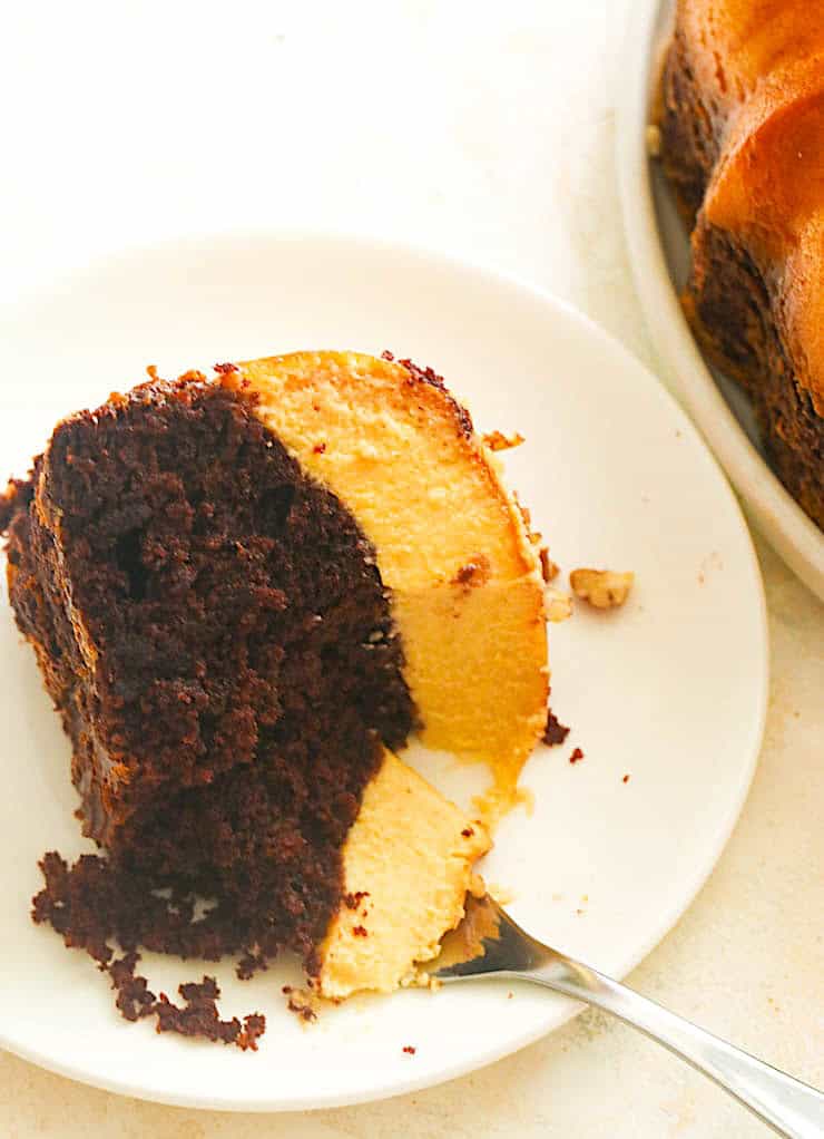 Forking into a decadent slice of chocolate cake topped with flan.