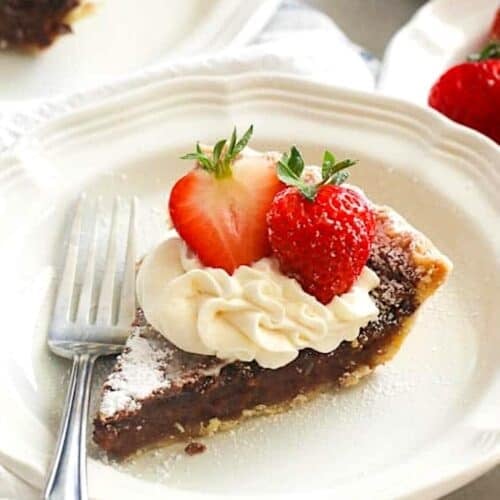 Enjoying a slice of chess pie with whipped cream and strawberries.