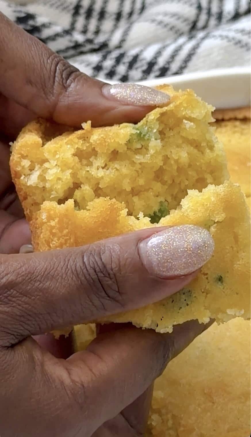 Breaking into a slice of cornbread that you can make in a skillet or baking dish.