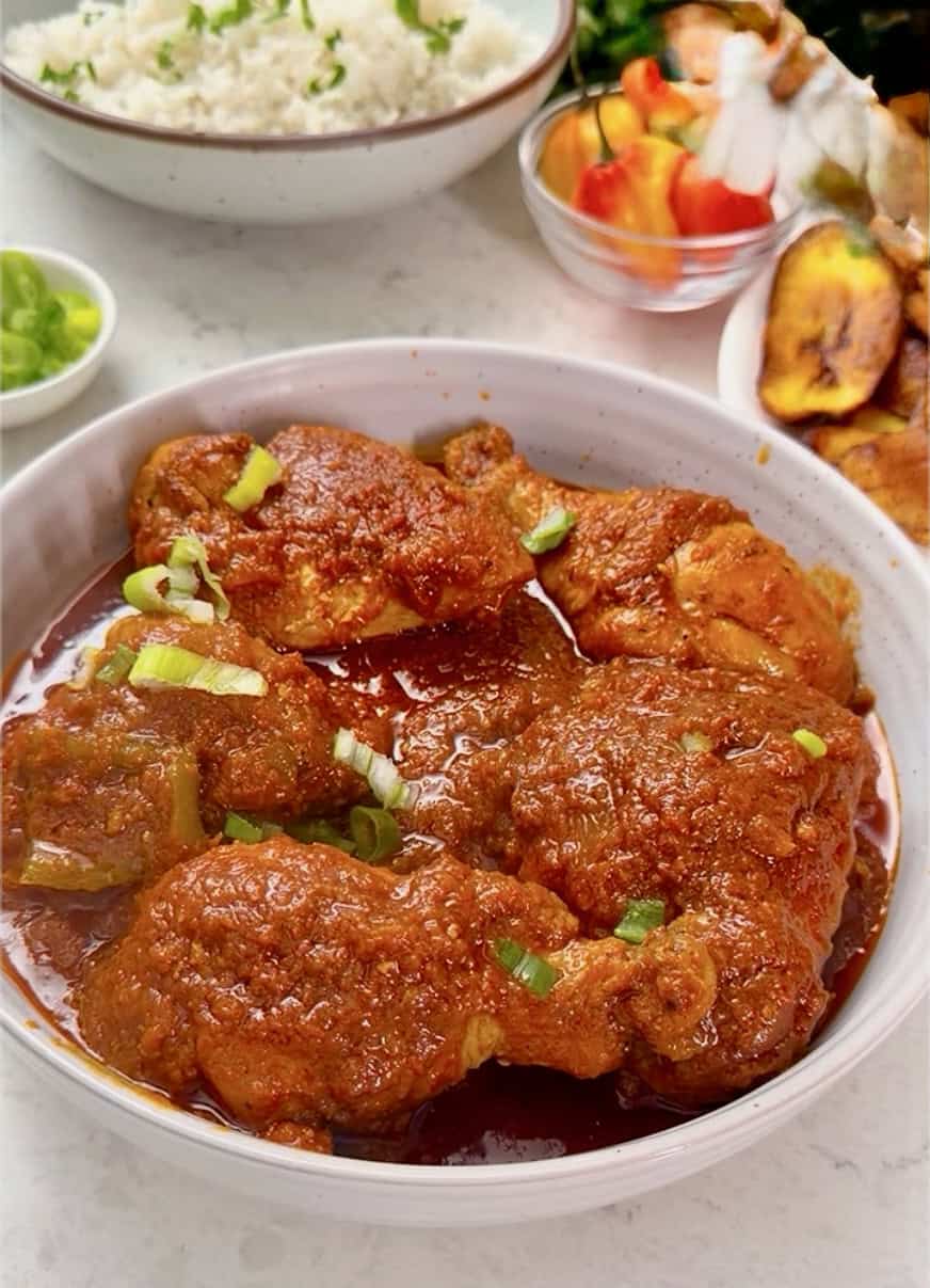 Steaming hot stew with chicken ready to serve with rice.