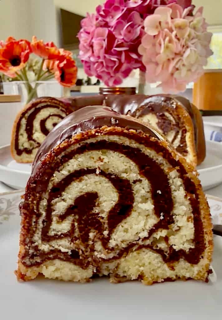 Slicing into an absolutely gorgeous cake marbled with vanilla and chocolate, then drizzled with chocolate frosting.