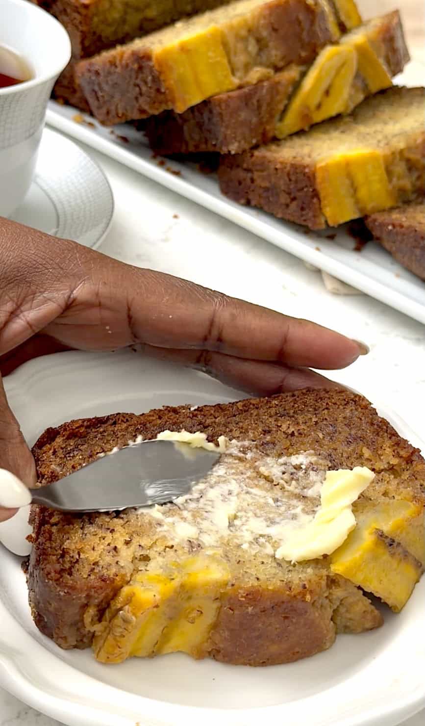 Slathering a slice of hot bread with butter.