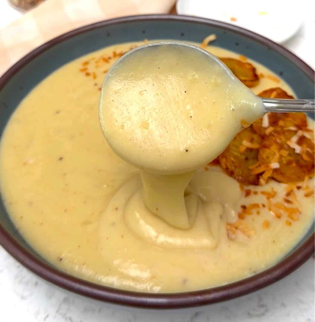 Enjoying a spoonful of porridge made with green plantains and coconut milk.