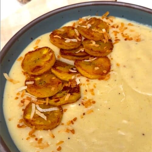 Enjoying a bowl of plantain porridge topped with fried plantains and toasted coconut.