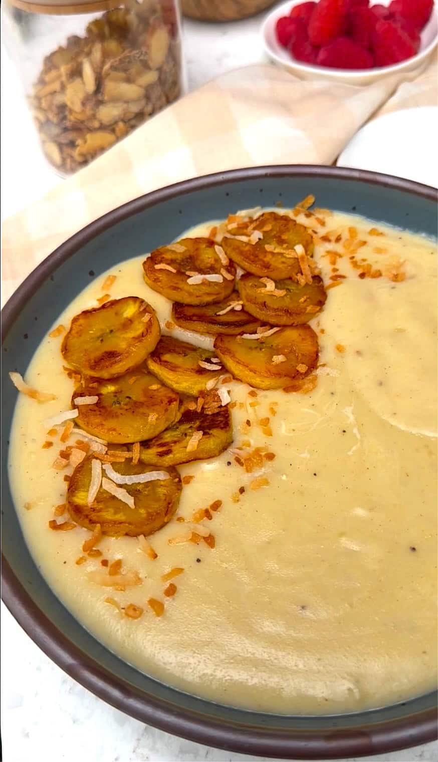 Enjoying a bowl of plantain porridge topped with fried plantains and toasted coconut.