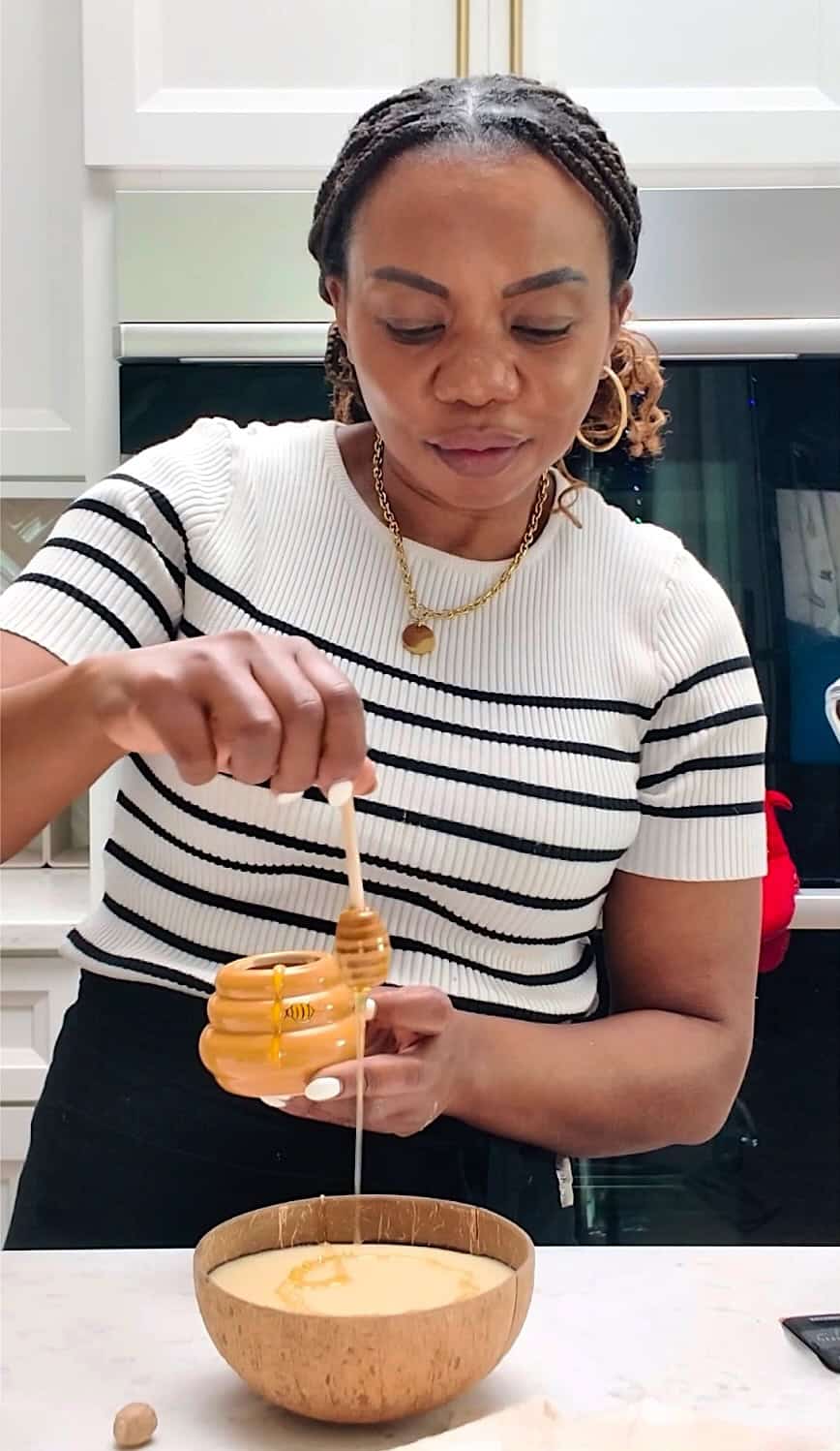 Drizzling honey over freshly made plantain porridge.