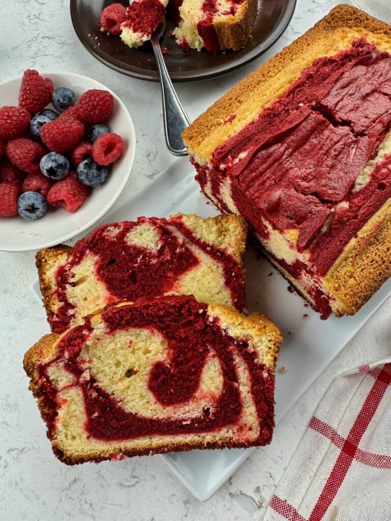 Slicing into a freshly baked red velvet marble pound cake to enjoy with a cup of coffee.