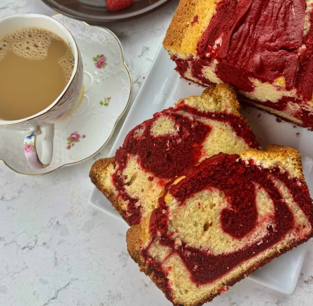 Freshly baked red velvet marble cake with a steaming hot cup of coffee.