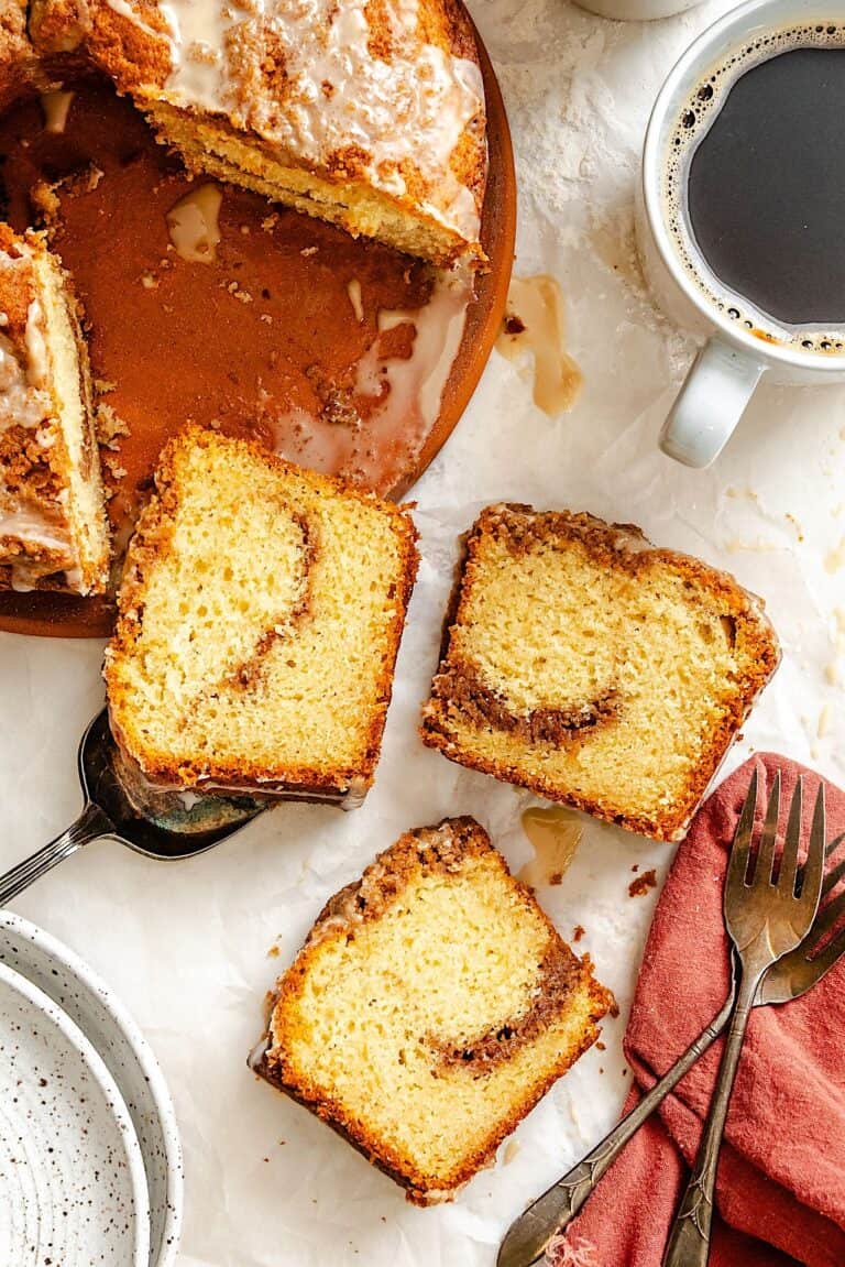 Slicing up and serving a sour cream coffee cake with a steaming hot cup of coffee.