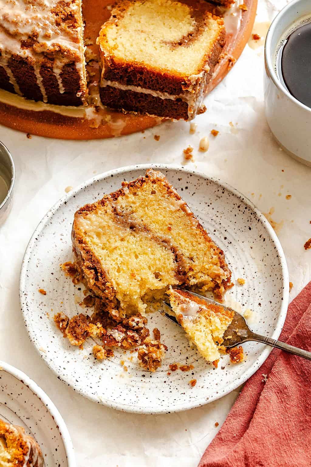 Enjoying a slice of a streusel topped cake with a hot cup of coffee.